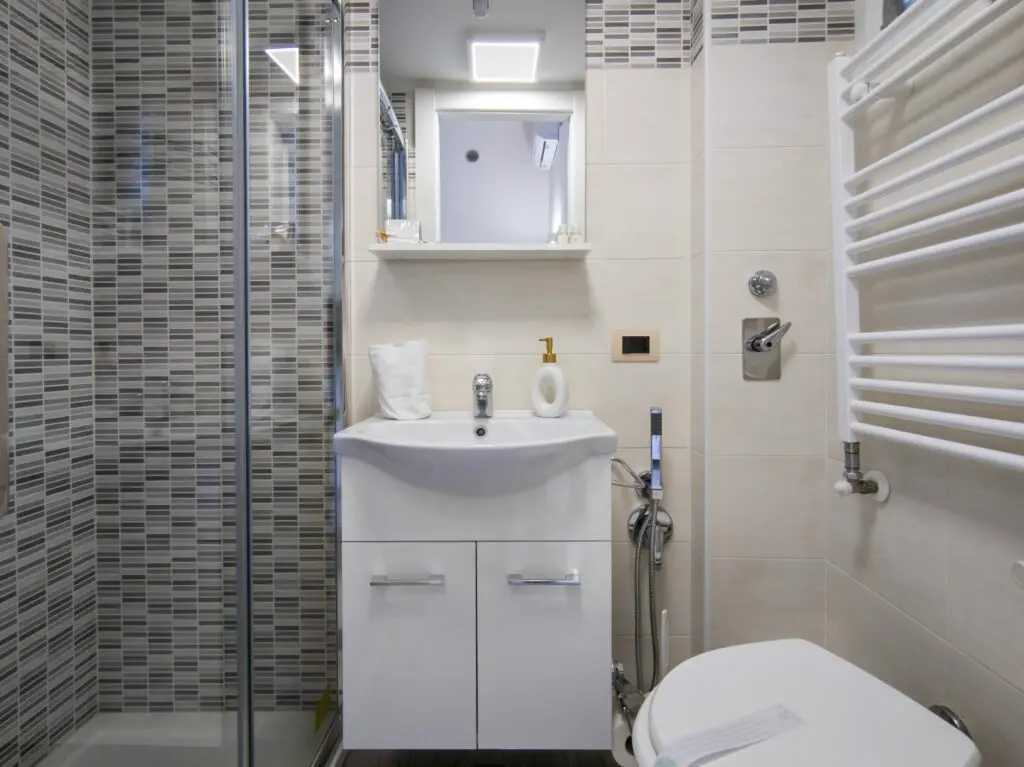 Bagno moderno con doccia, lavandino bianco e piastrelle decorate