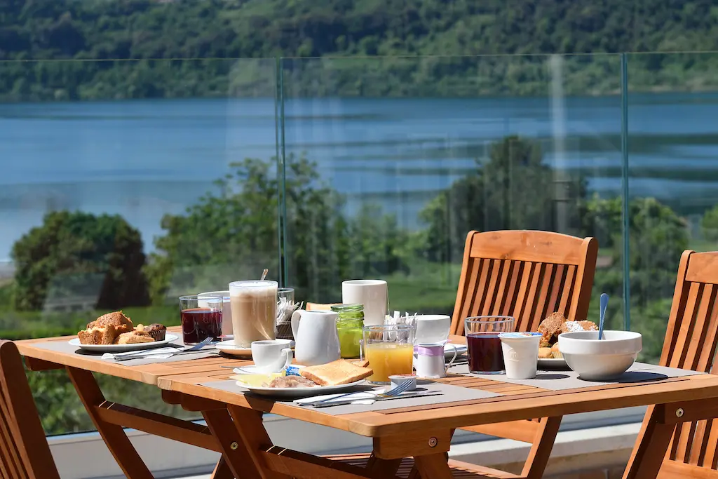 Colazione su un tavolo all'aperto con vista sul Lago di Nemi