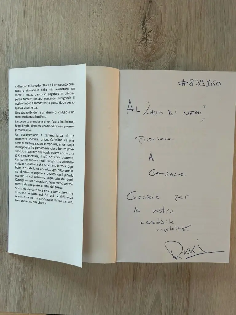 Libro aperto con dedica scritta a mano sulla destra e testo stampato sulla sinistra